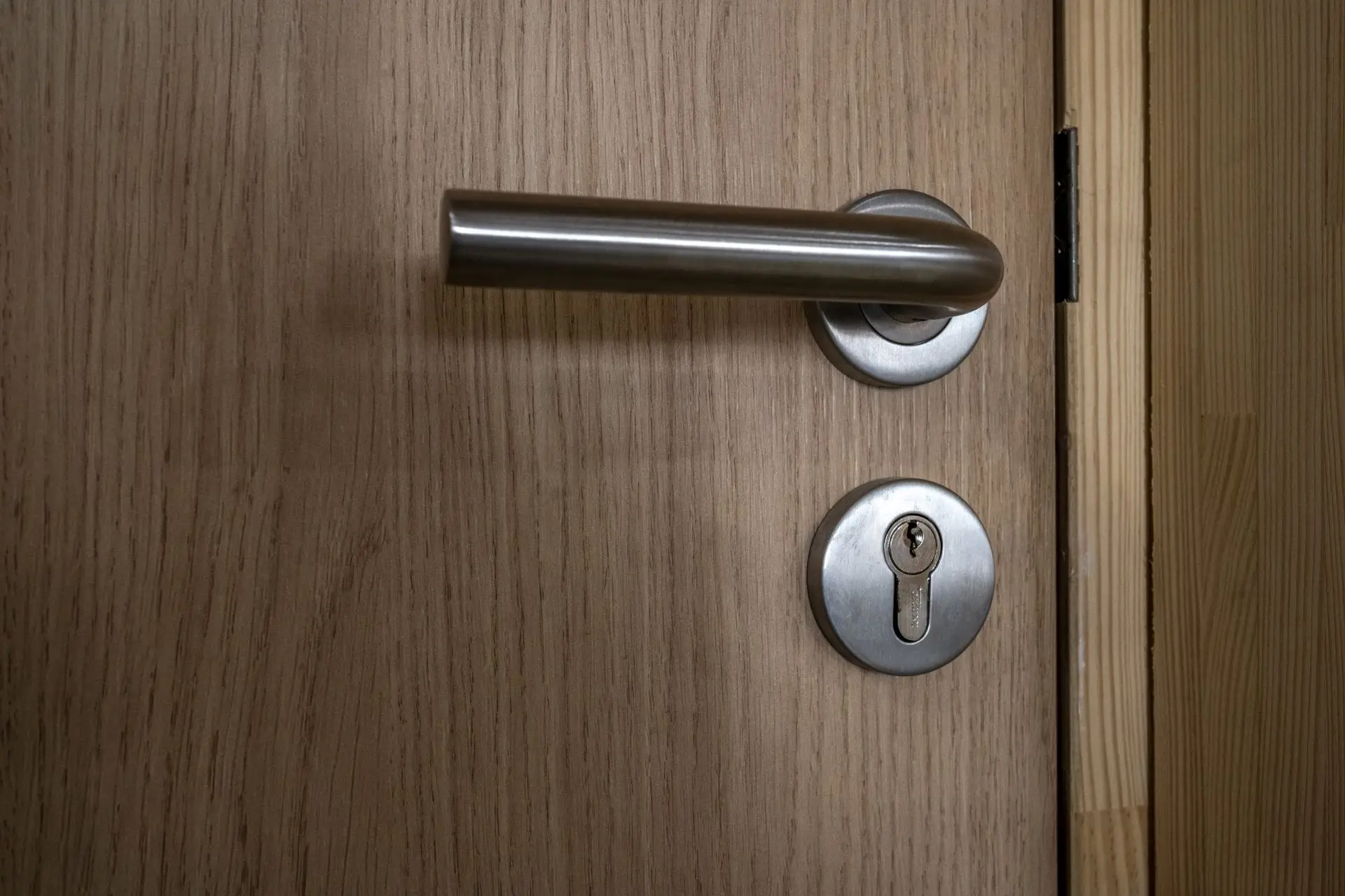 Poignee de porte en acier brosse sur porte en bois