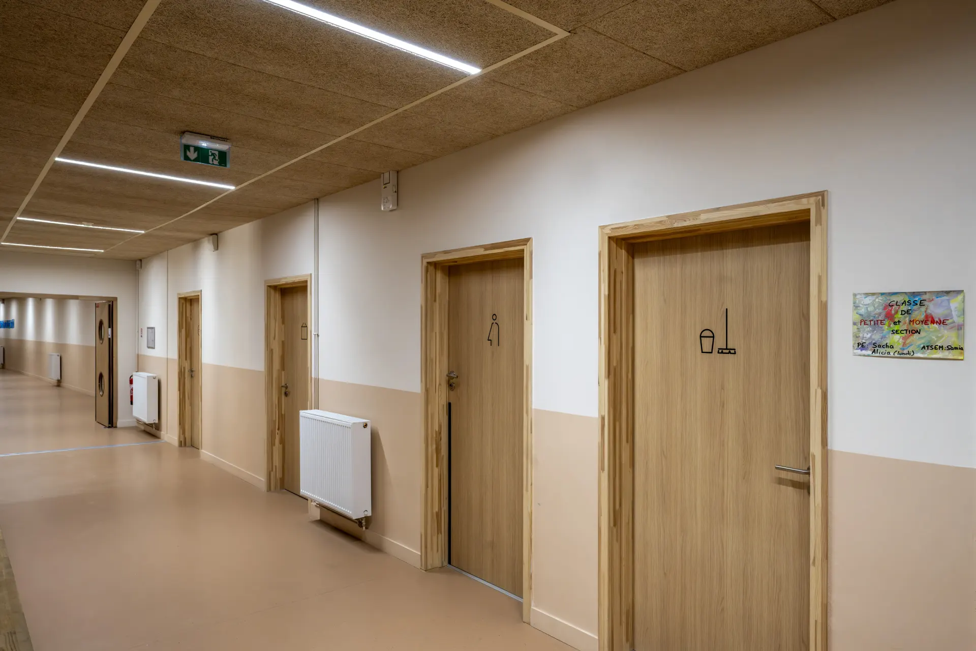 Couloir scolaire avec portes bois de sanitaires et signaletique integree, realisation IROKO